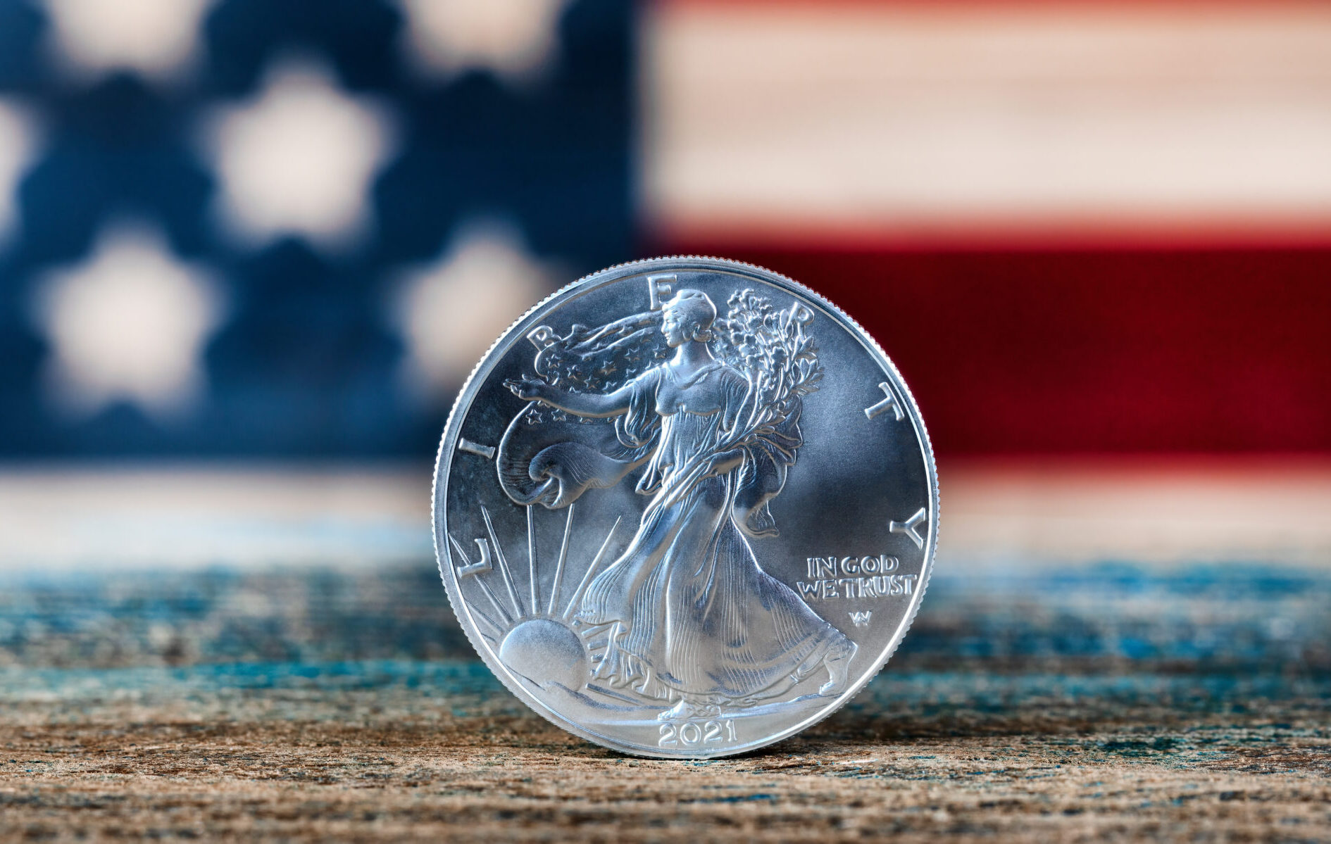 American silver eagle dollar coin with US flag in background